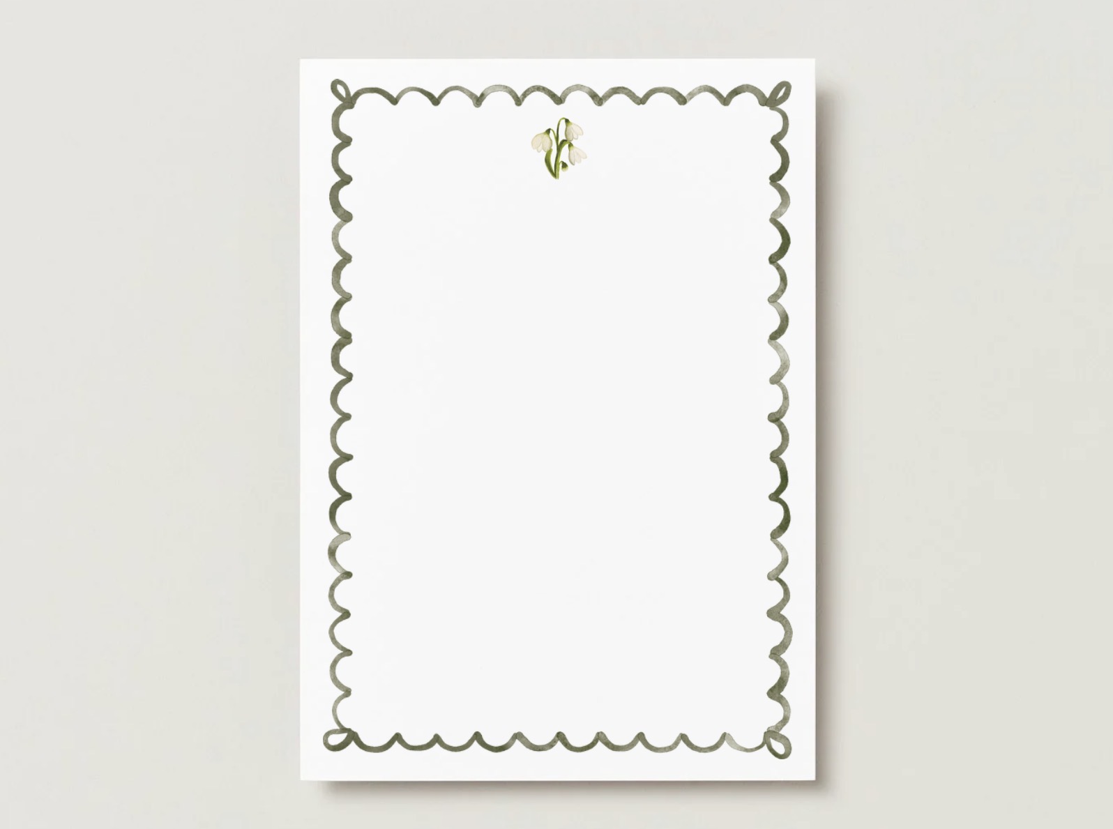 Snowdrop birth flower A7 flat card with a scalloped green watercolor border on a pale gray background